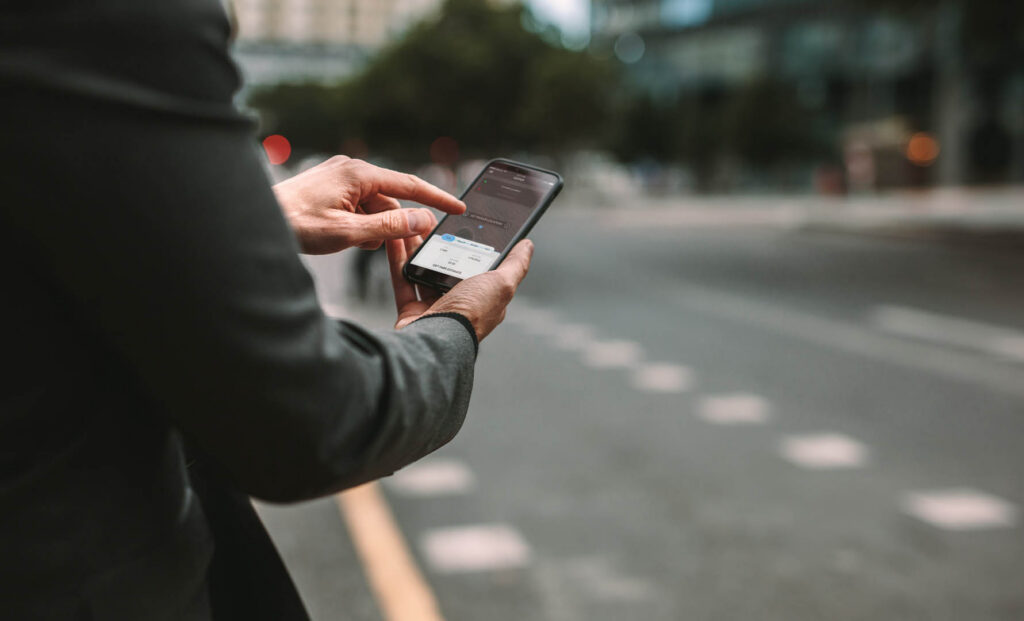 Online ride sharing and carpool mobile application. Rideshare taxi app on smartphone screen. Male commuter using online transportation service.